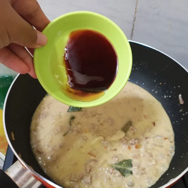 Setelah mendidih, tambahkan kecap manis, kecap asin dan minyak wijen. Aduk, Masak kembali sampai air menyusut