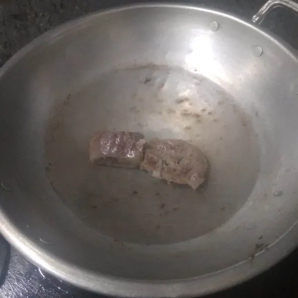 Rebus daging dengan 400 ml air selama 5 menit lalu buang airnya. Iris-iris daging lalu rebus kembali dengan 1 liter air hingga empuk.