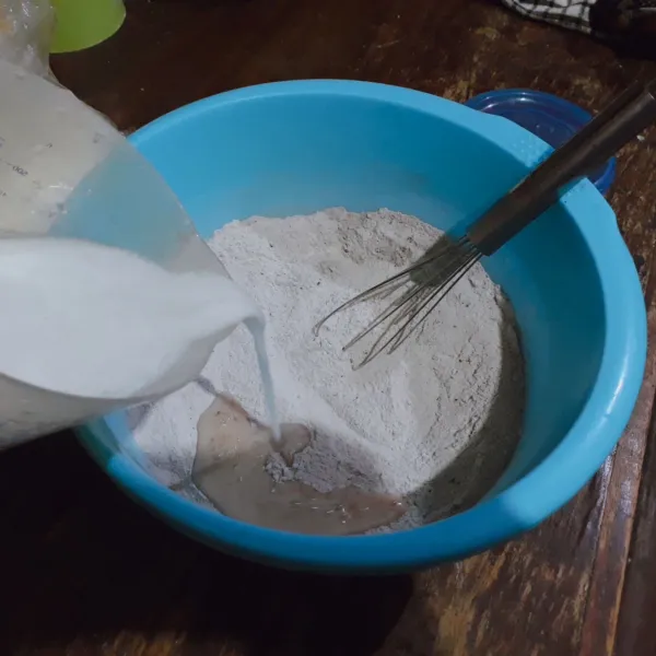 Tuang air ke dalam tepung, aduk rata dengan whisk.