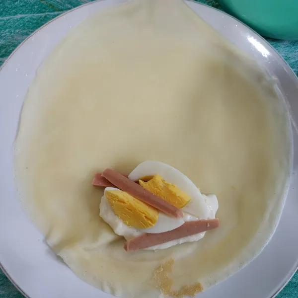 Ambil satu lembar bahan kulit, tambahkan campuran mayonaise secukupnya, sosis dan telur lipat bentuk amplop. Lakukan hingga semua selesai.