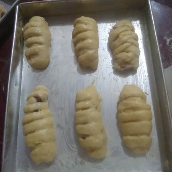 Tata diloyang yang sudah diolesi margarin. Olesi bagian atasnya dengan butter yang sudah dicampur susu cair.