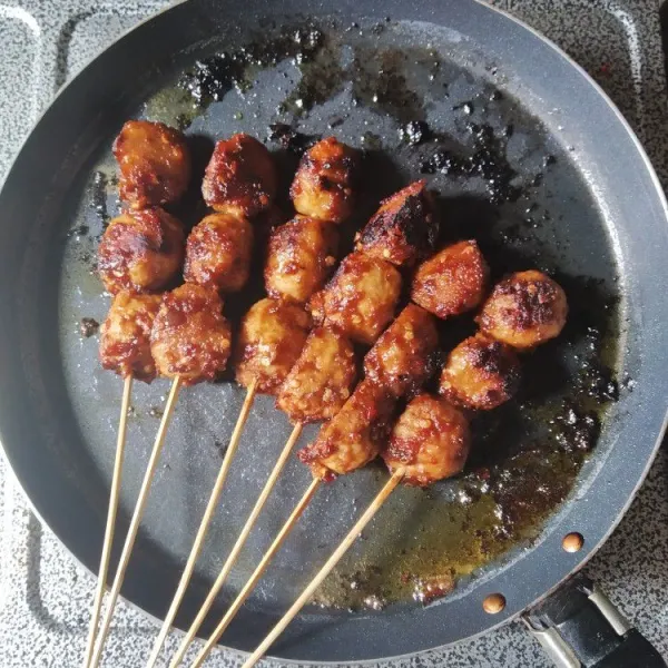 Bakar bakso di atas teflon hingga kecoklatan, sambil dioles dengan sisa bumbu, sajikan hangat.