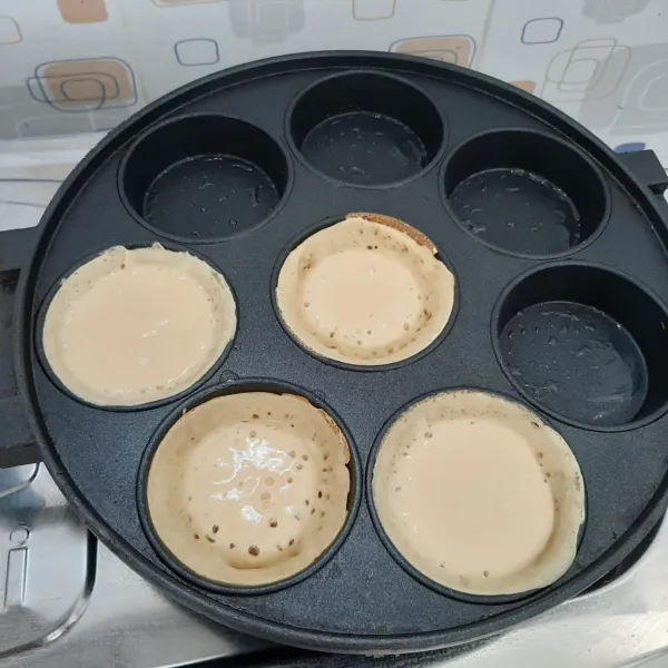 Panaskan cetakan, oles margarin. tuang adonan 1 sendok sayur, tekan sedikit untuk membentuk pinggiran. Tunggu sampai adonan matang.