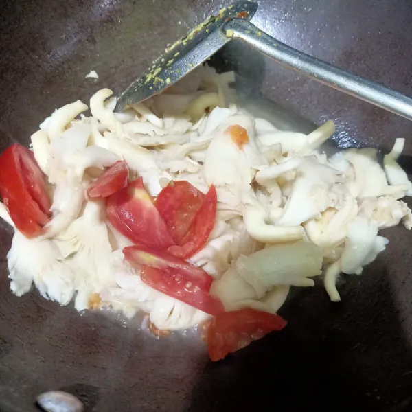 Masukkan irisan tomat kedalam wajan, oseng sampai tercampur rata lalu masukkan air.