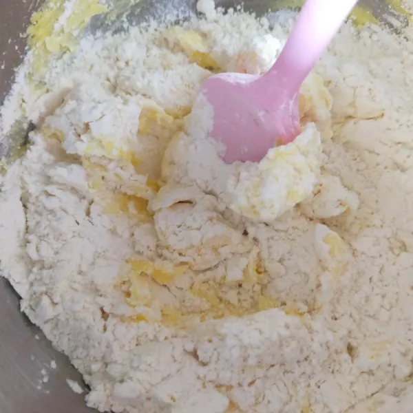 Masukkan tepung, maizena dan susu bubuk ke dalam adonan butter. Aduk dengan spatula.