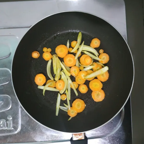 Tumis bawang bombay dan wortel dengan sedikit minyak, masak hingga harum.