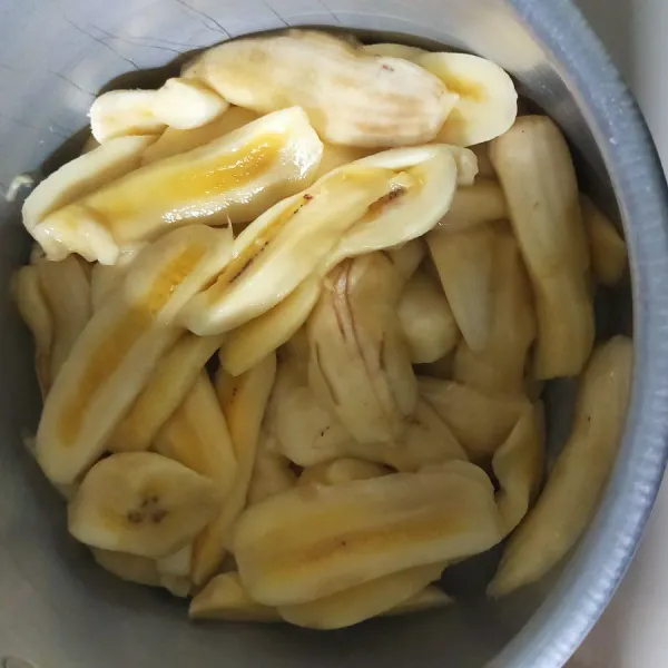 Kupas pisang dan pisahkan dari bijinya.