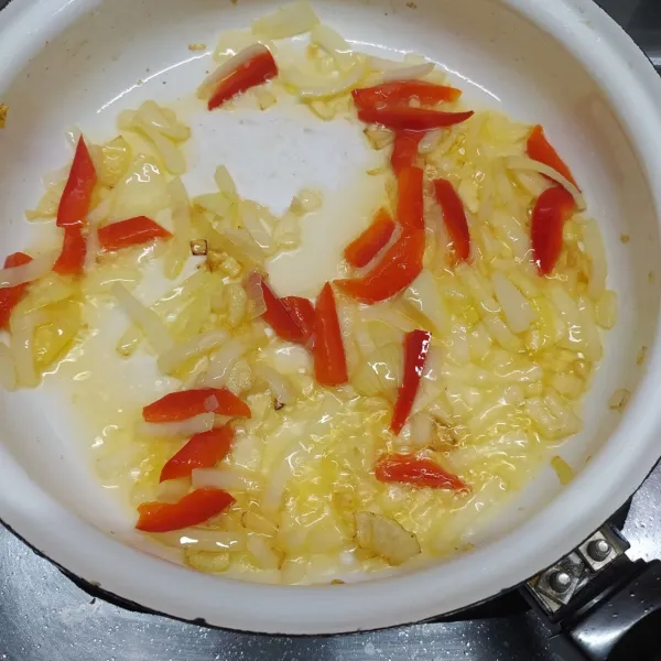 Tumis bawang putih cincang, bawang bombay dan paprika merah sampai layu dan harum. Kemudian, masukkan irisan nanas dan aduk sebentar.