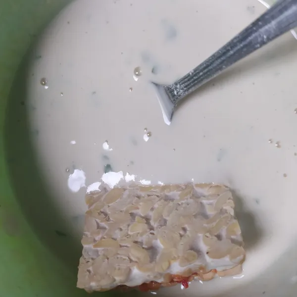 Celupkan tempe ke dalam adonan tepung.