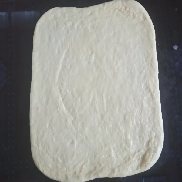 Ratakan dough menggunakan rolling pin sehingga berbentuk persegi panjang