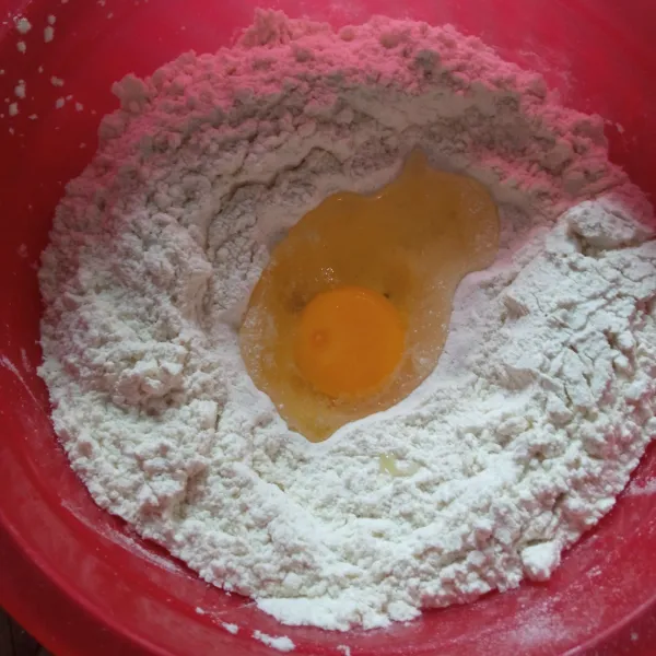 Siapkan wadah, masukkan tepung, telur, ragi dan gula pasir. Uleni hingga setengah kalis