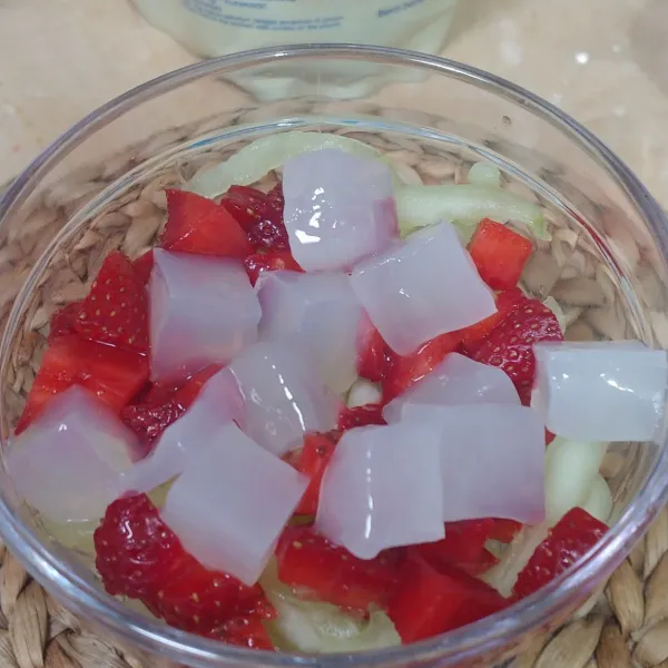 Tambahkan buah strawberry yang sudah diiris kecil dan nata de coco