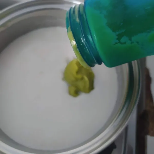 Tuang blenderan alpukat ke dalam puding, aduk rata.