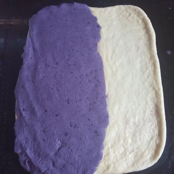 Bagi dough menjadi 2 sisi. Beri salah satu sisinya dengan pasta ubi ungu, ratakan