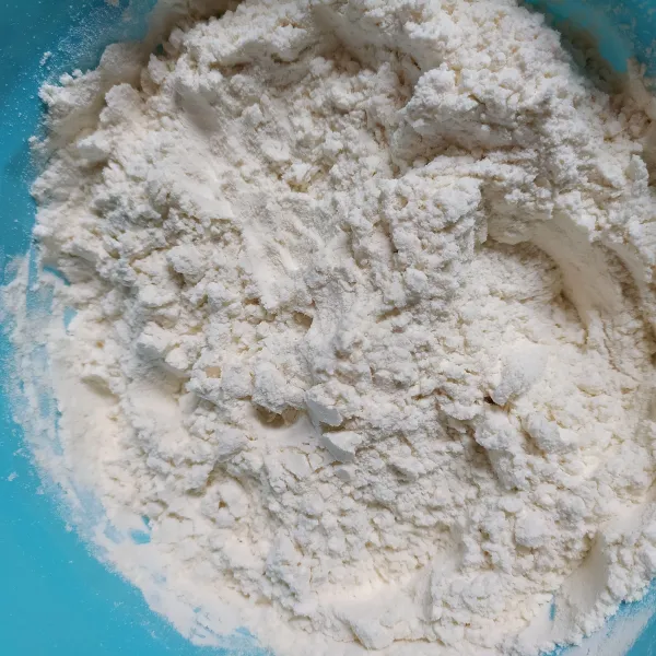 Masukkan tepung terigu dalam wadah, tambahkan ragi instan dan gula pasir. Aduk rata.