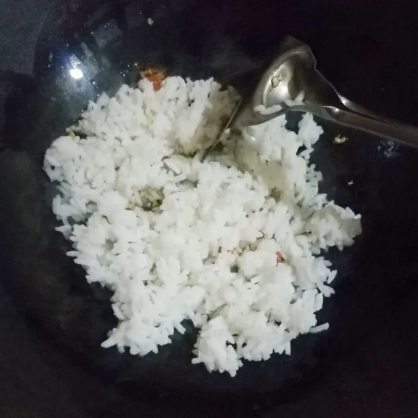 Masukkan nasi putih dingin kemudian aduk hingga tercampur rata.