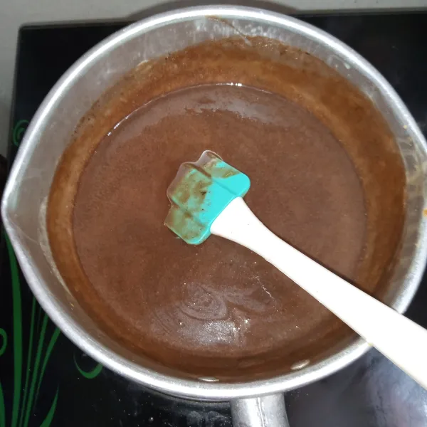 Masak hingga mendidih, masukkan cokelat button. Aduk sebentar dan matikan api.