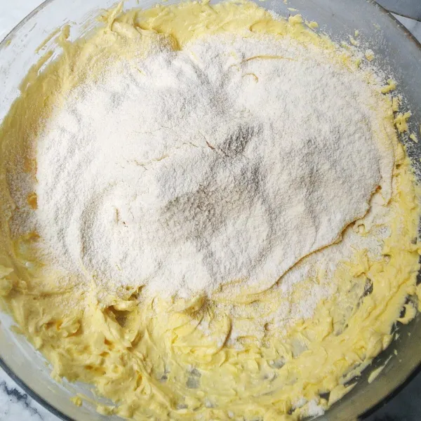 Masukkan tepung terigu, maizena, dan vanili bubuk yang sudah diayak sedikit demi sedikit. Mixer pake kecepatan paling rendah.