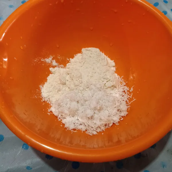 Campur terigu, kelapa parut dan garam dalam mangkuk.