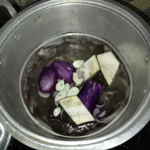 Rebus air, terong, bawang merah, bawang putih dan daun salam.
