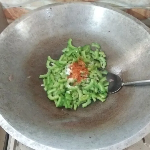 Setelah pare empuk masukkan gula pasir, garam, kaldu bubuk dan cabai bubuk, aduk rata.