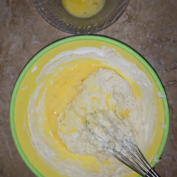 Masukkan kocokan telur secara bertahap. Lalu uleni hingga adonan seperti lem