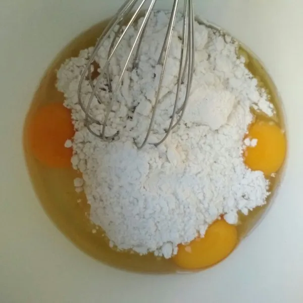 Dalam bowl aduk dengan whisk telur ayam dan gula halus hingga gula larut