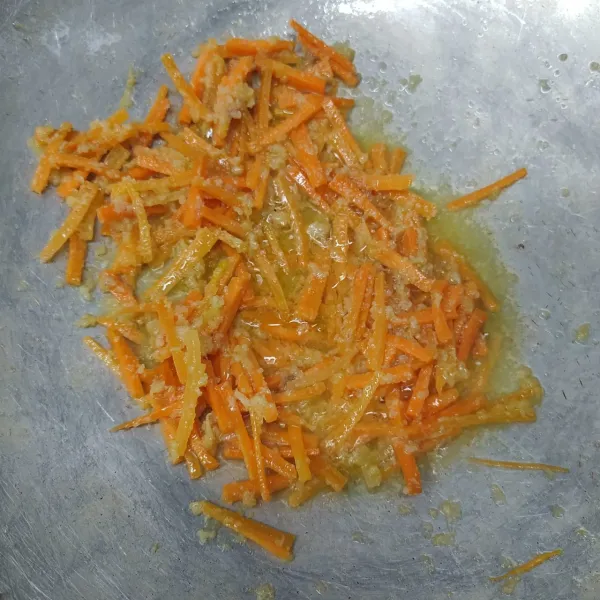Masukkan irisan wortel, masak sampai ½ matang