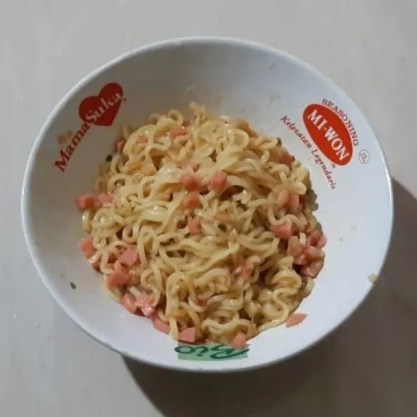 Masukkan bumbu mie instant ke dalam mangkuk masukkan mie dan sosis, aduk rata.