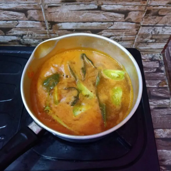 Rebus bersama ikan bandeng, salam, sereh, asam jawa serta tomat hijau.