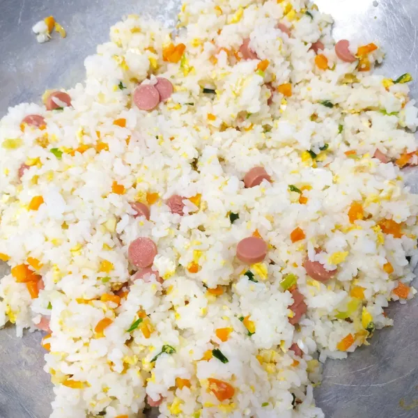 Masukkan nasi, sosis, bumbui merica bubuk, kaldu jamur dan garam. Aduk rata sambil koreksi rasa sesuai selera. Angkat dan sajikan.