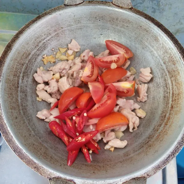 Masukkan ayam, tomat dan cabai merah. Aduk rata. Masak sampai ayam berubah warna.