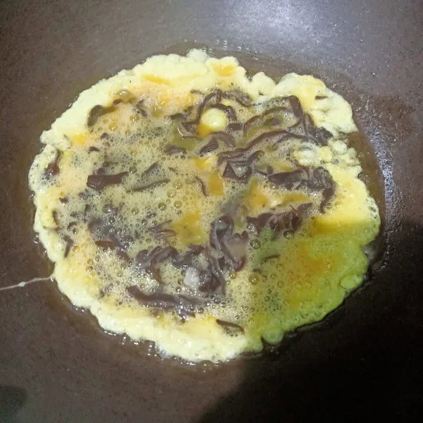 Siapkan wajan lalu beri sedikit minyak goreng. Setelah panas minyak masukkan adonan telur dadar, diamkan beberapa menit hingga satu sisi matang.