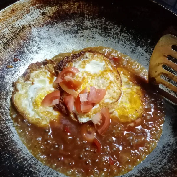 Masukkan telur ceplok dan tomat, aduk rata. Masak sampai bumbu meresap.