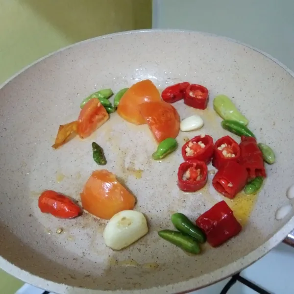 Goreng bahan sambal : cabe merah, cabe rawit, tomat dan bawang putih hingga berubah warna