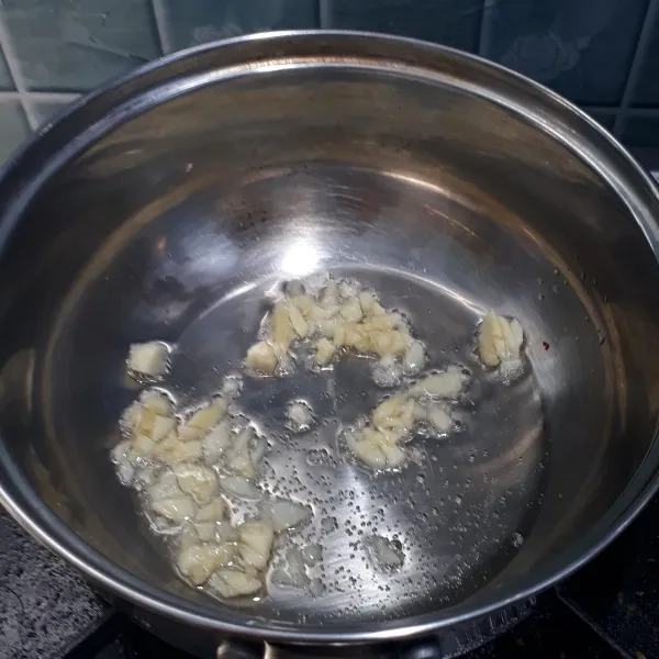 Panaskan minyak goreng lalu tumis bawang putih hingga harum.