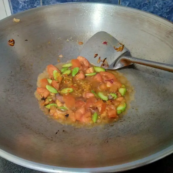 Kemudian masukkan tomat. Aduk. Lalu tuang secukupnya air. Masak hingga tomat matang.