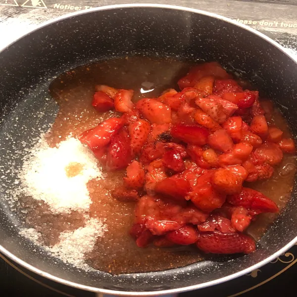 Cincang kasar strawberry dan taruh di pan anti lengket bersama gula