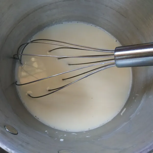 Campur susu cair, kental manis, gula dan keju parut aduk rata kemudian masak hingga mendidih.