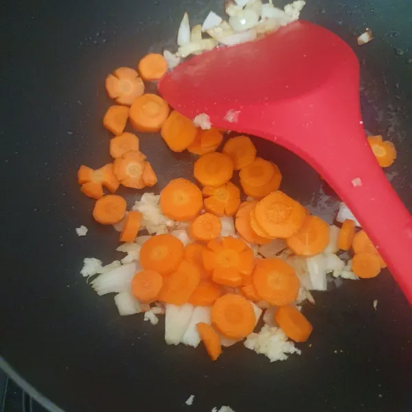 Masukkan potongan wortel, masak hingga agak layu.