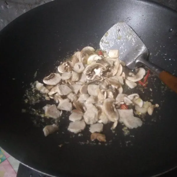 Masukkan irisan baso dan jamur kancing. Aduk rata. Masak hingga jamur layu.