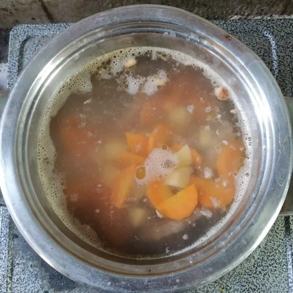 Cuci bersih dan potong-potong sayuran sesuai selera. Masukkan kentang dan wortel, masak hingga sayuran empuk.