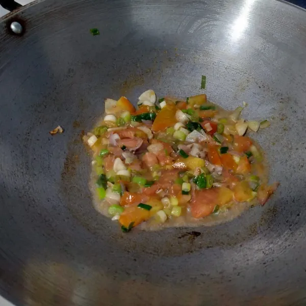 Kemudian masukkan bawang prei dan tomat. Aduk. Lalu tuang secukupnya air. Masak hingga tomat lunak.
