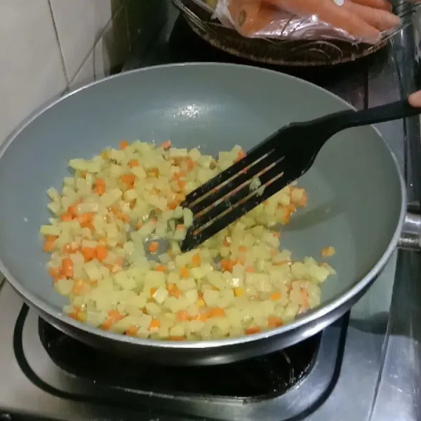 Memasak bahan isi: tumis bumbu halus hingga harum, masukkan kentang dan wortel yang sudah dicuci bersih, tambahkan garam masak sampai sayur matang. Angkat sisihkan