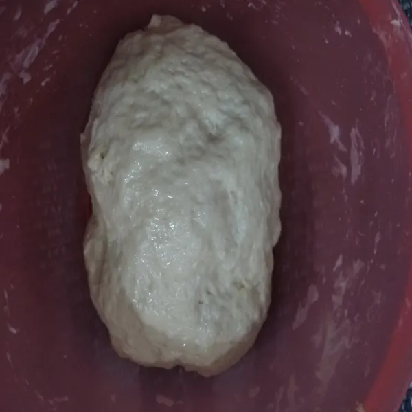 Masukkan margarin dan garam, aduk (agak diremas-remas) hingga tercampur rata lalu bentuk bulatan besar di tengah wadah, diamkan hingga mengembang 2×