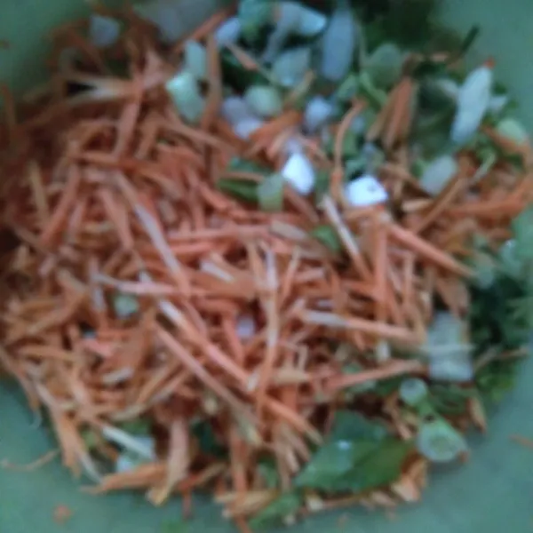 Kupas cuci wortel. Serut wortel dan potong kecil daun bawang dan seledri.