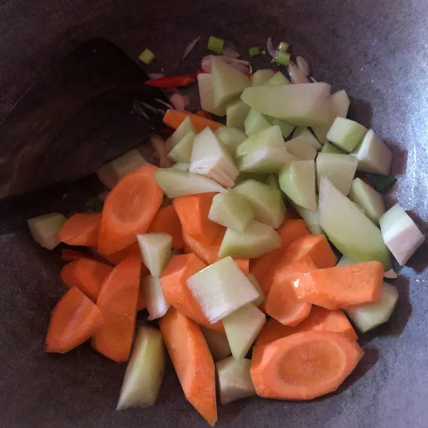 Masukkan wortel dan labu siam, aduk rata. Masukkan air dan bumbui dengan garam dan kaldu jamur. Biarkan wortel dan labu siam empuk.