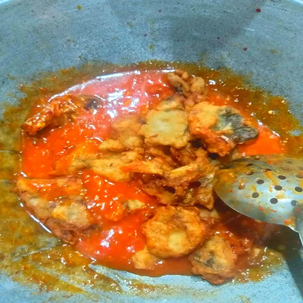 Tumis bumbu bawang merah dan bawang putih hingga harum dan matang. Masukkan ikan goreng tambahkan bumbu pelengkap dan larutan tepung, aduk-aduk rata koreksi rasa