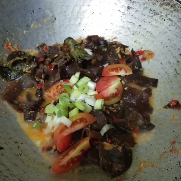 Masukan irisan bawang daun dan tomat, masak hingga jamur matang