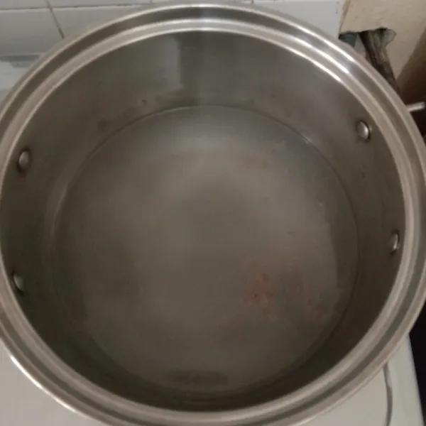 Siapkan panci, tuang air kelapa dan tambahkan air bersih.